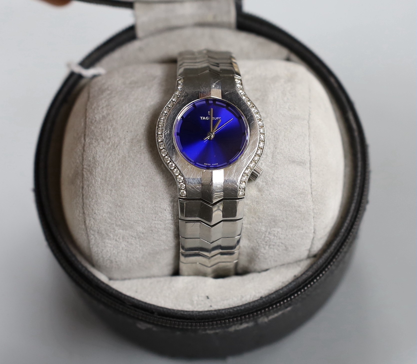 A lady's stylish modern steel Tag Heuer quartz wrist watch and bracelet, with blue dial and diamond chip set bezel, with boxes.